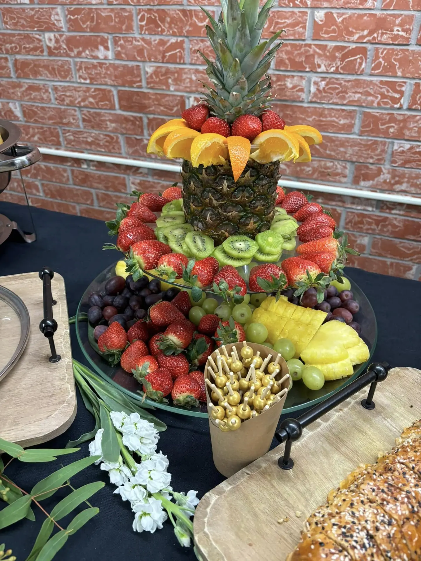 Tiered fresh fruit display crowned with a carved pineapple